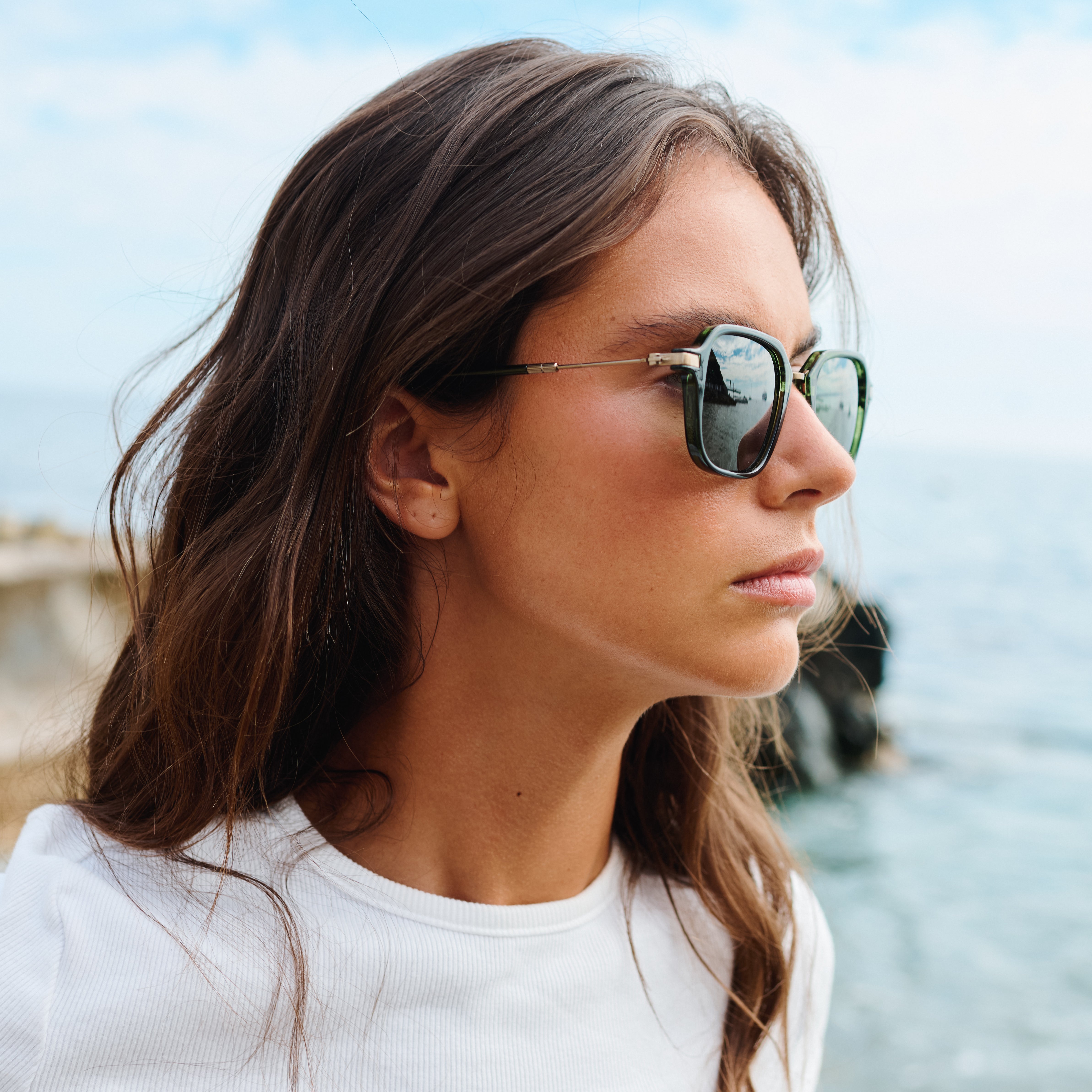 Woman wearing sunglasses with a blurred natural background. Color:
EMERALD / GREEN POLARIZED LENS