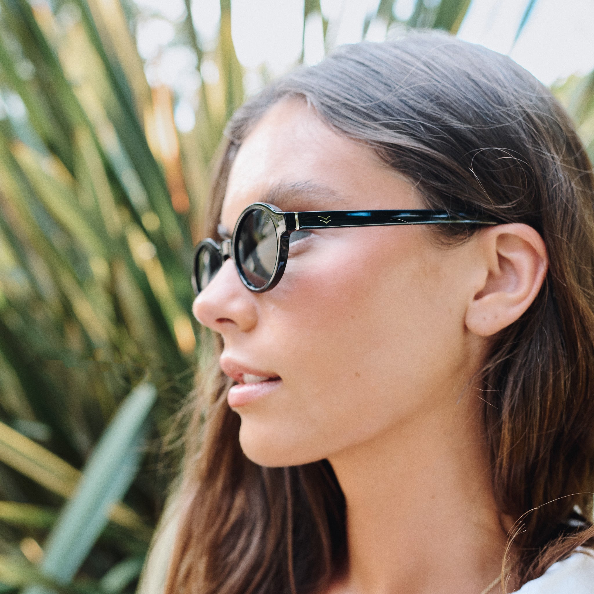 Woman wearing sunglasses with a blurred natural background.
BLACK / SMOKE POLARIZED LENS