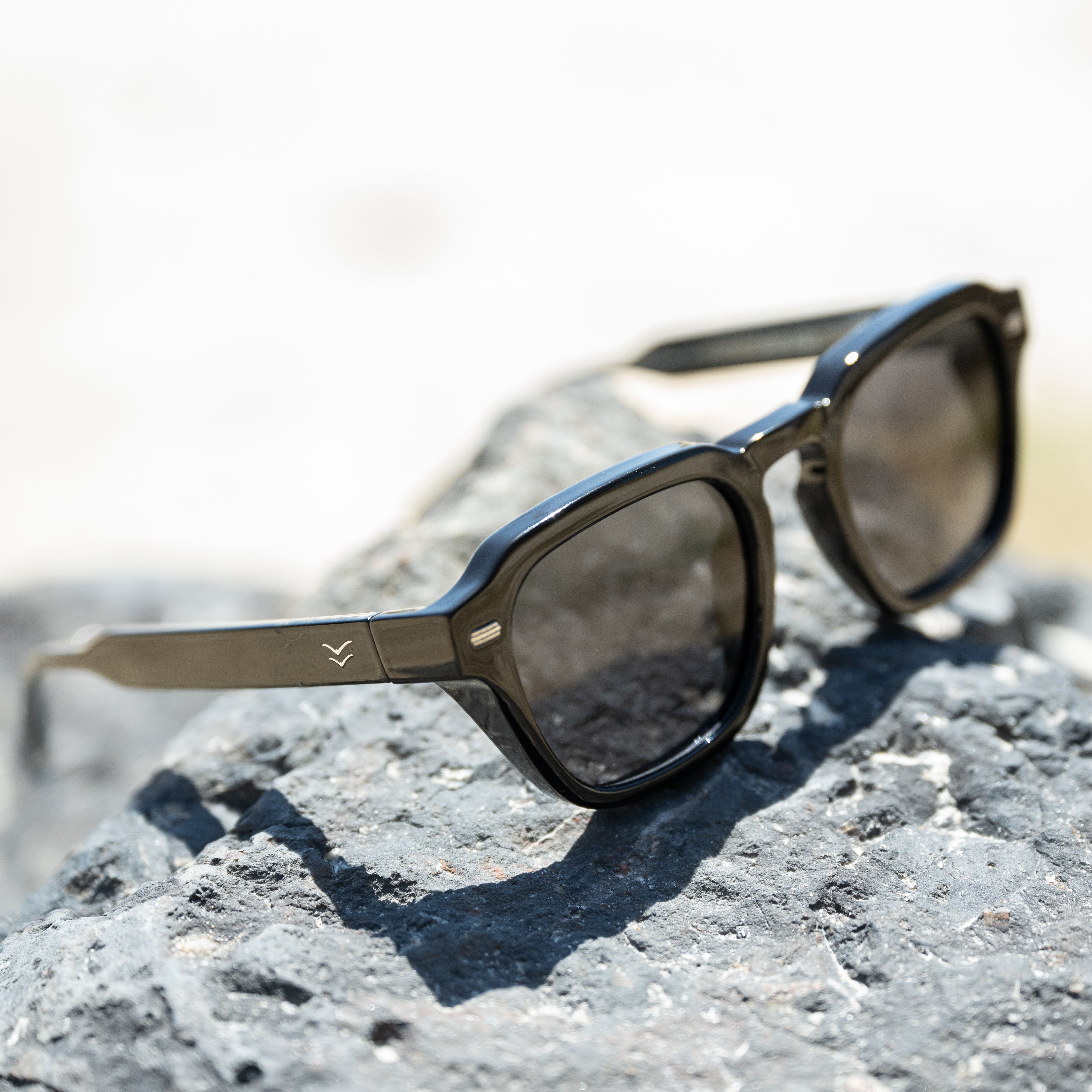 Sunglasses on a rock with a blurred natural background.
BLACK / SMOKE POLARIZED LENS