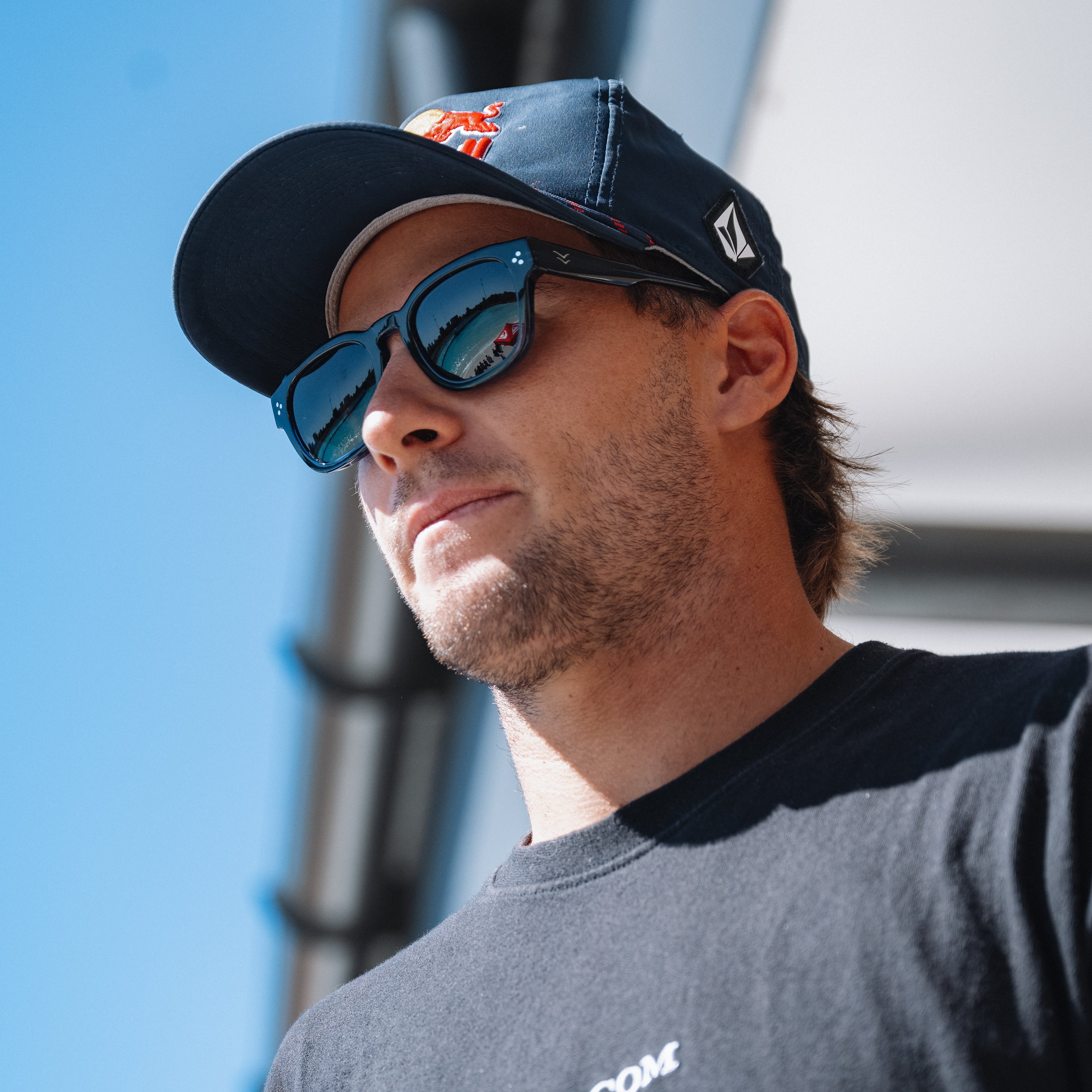 Man wearing a navy cap and sunglasses with a blue sky background.
BLACK / GREEN POLARIZED LENS