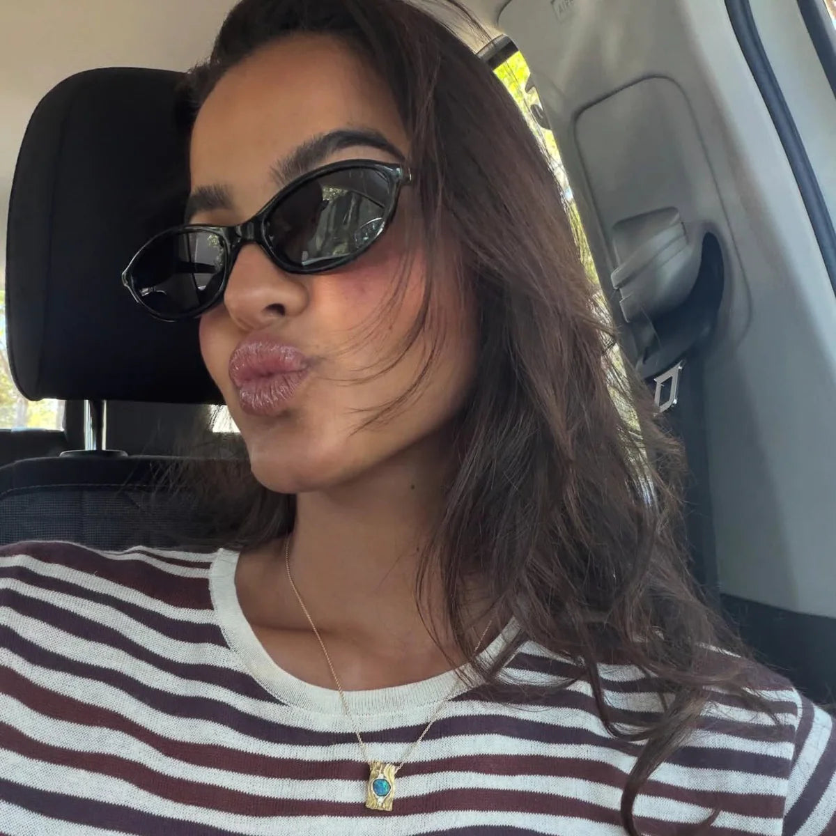 Woman wearing sunglasses and a striped shirt inside a car.
BLACK / SMOKE POLARIZED LENS