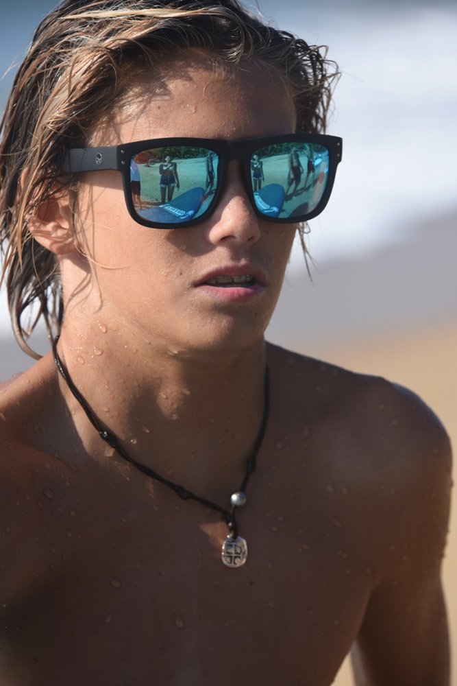 Person wearing reflective sunglasses with a beach background.
BLACK SOFT TOUCH RUBBER / BLUE MIRROR POLARIZED