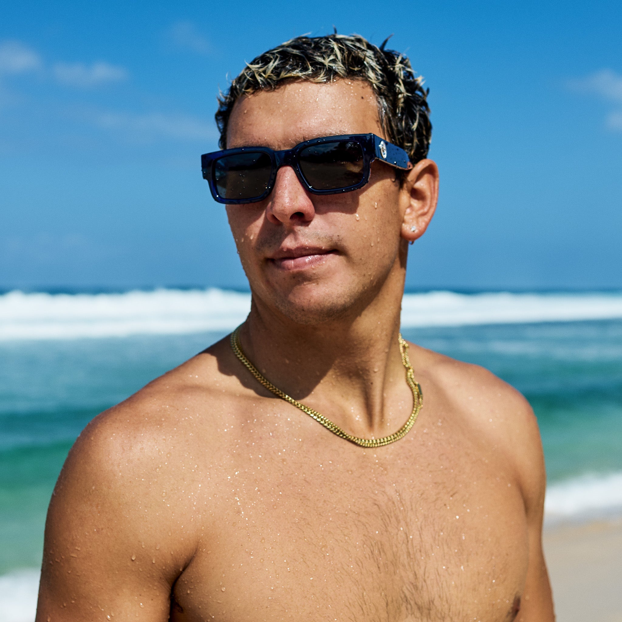 Man wearing sunglasses on a beach with ocean waves in the background.
DARK SEAS / SMOKE POLARIZED LENS