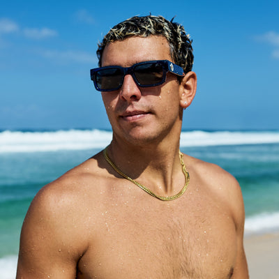Man wearing sunglasses on a beach with ocean waves in the background.
DARK SEAS / SMOKE POLARIZED LENS