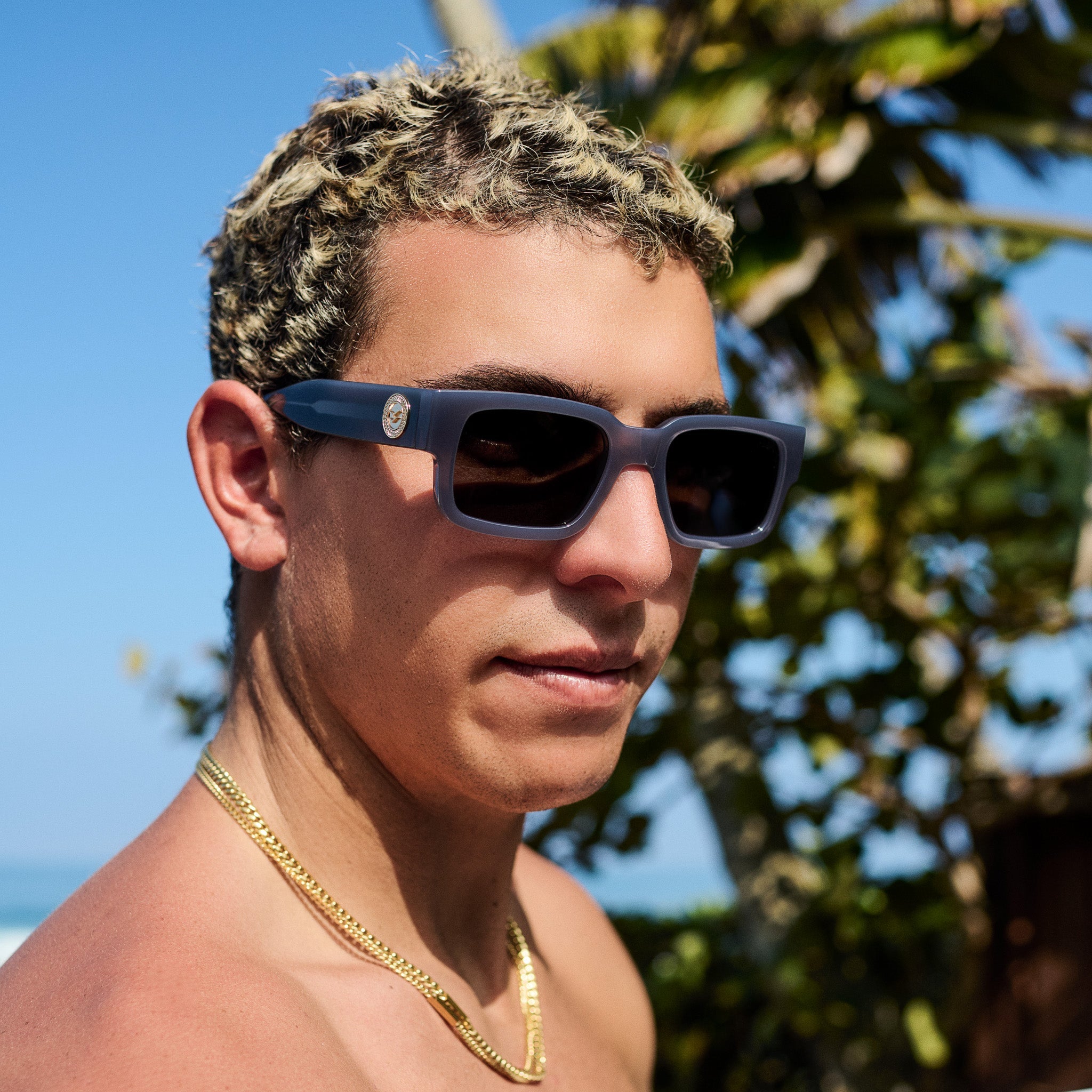 Man wearing sunglasses with a tropical background.
GREY / SMOKE POLARIZED LENS