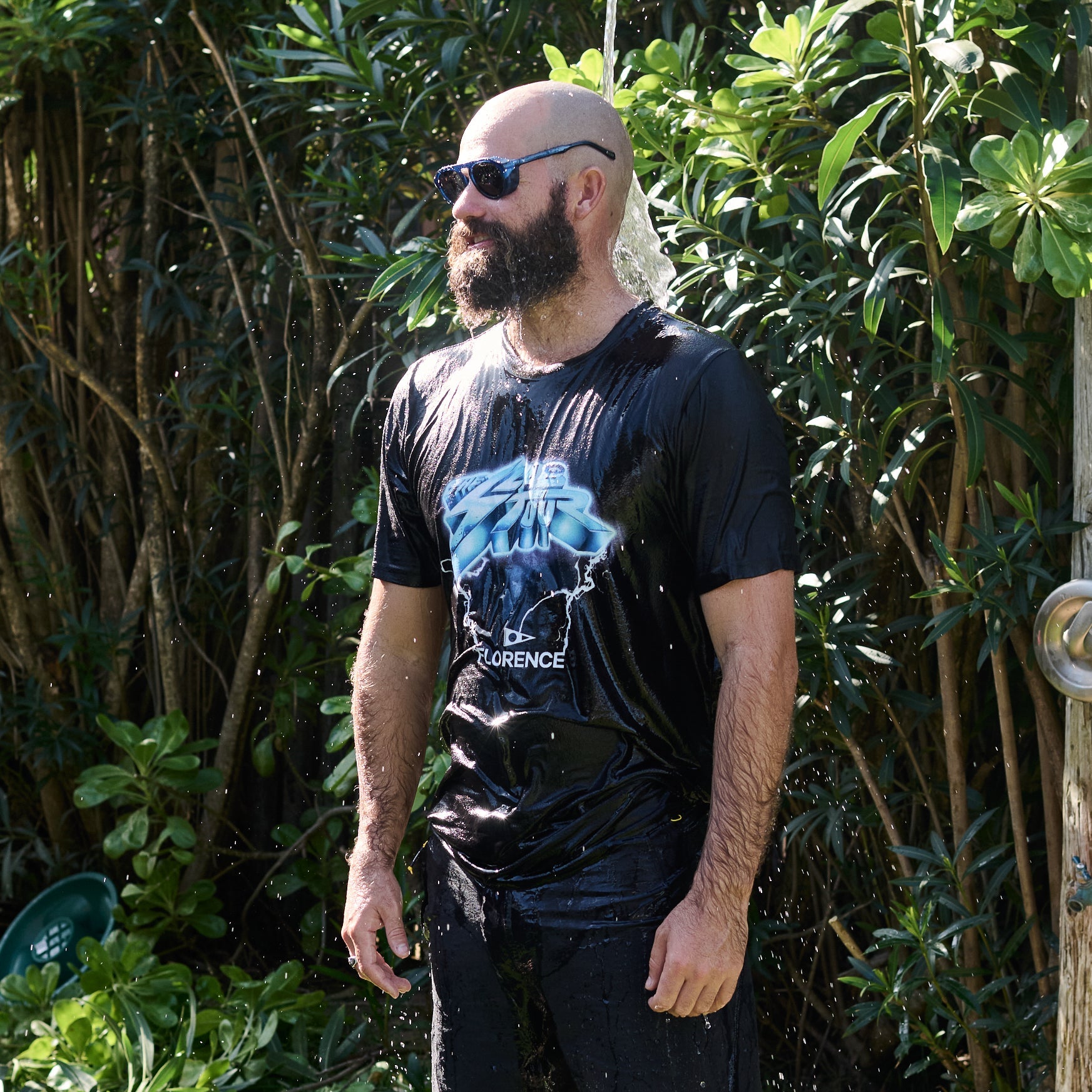 Man standing outdoors with plants in the background