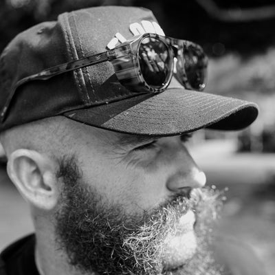 Man wearing a cap with sunglasses on top, black and white photo