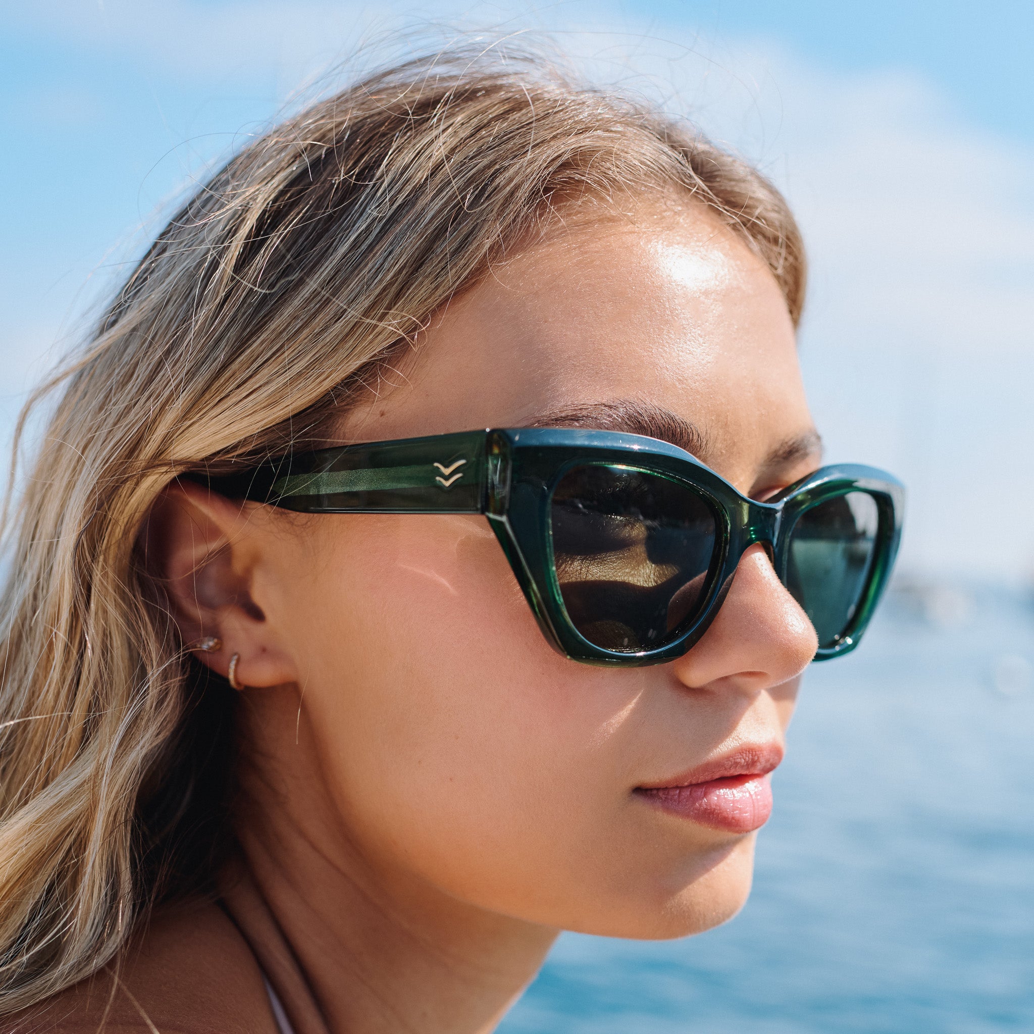 Woman wearing green sunglasses with a blurred background of water and sky.
EMERALD / GREEN POLARIZED LENS