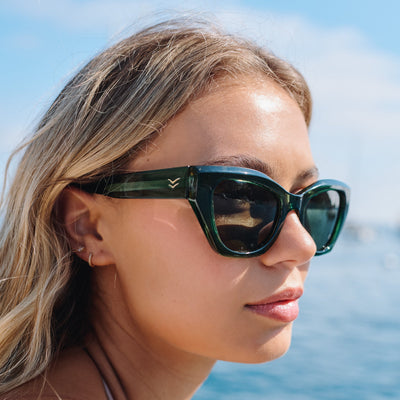 Woman wearing green sunglasses with a blurred background of water and sky.
EMERALD / GREEN POLARIZED LENS