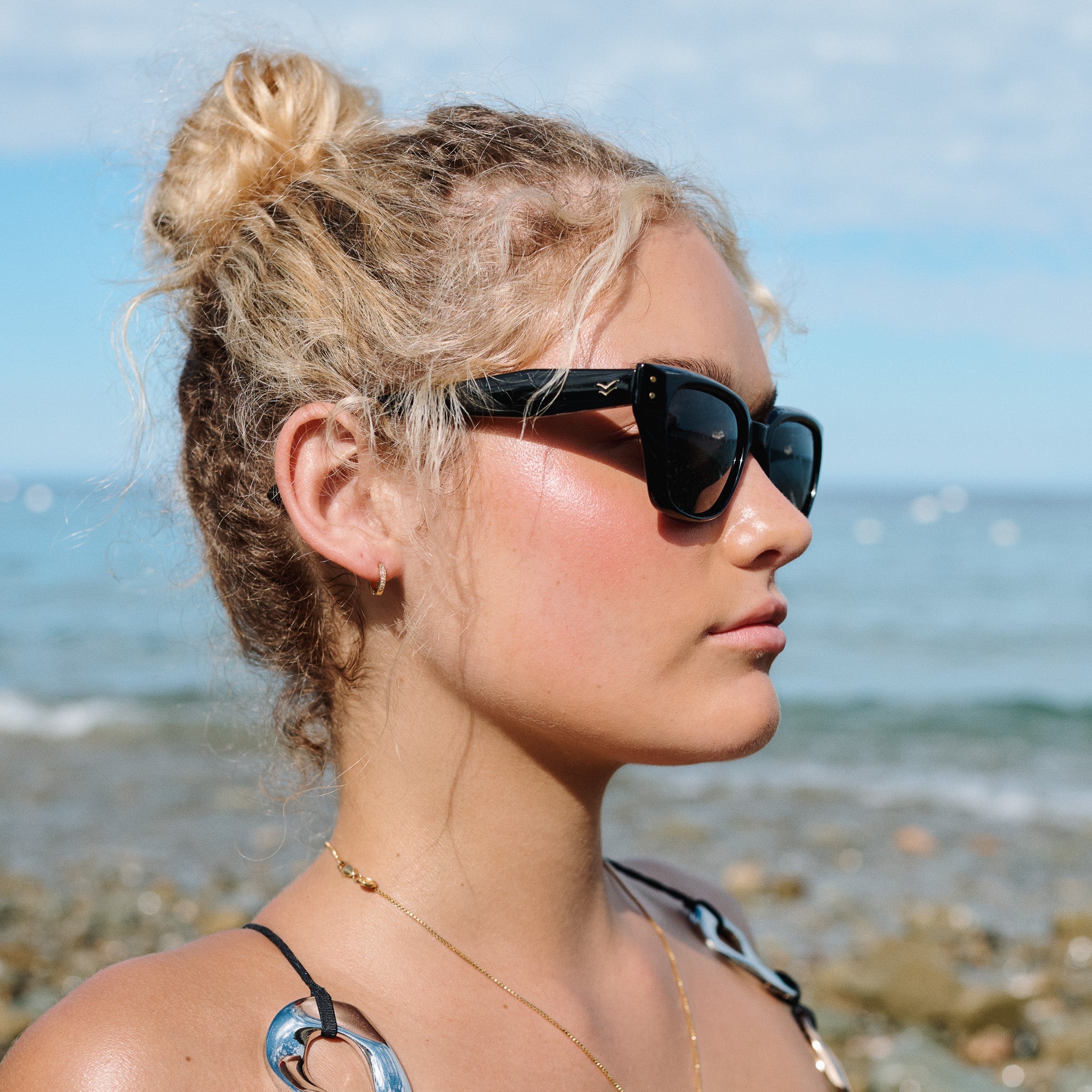 Woman wearing sunglasses with a beach background.
BLACK / SMOKE POLARIZED LENS
