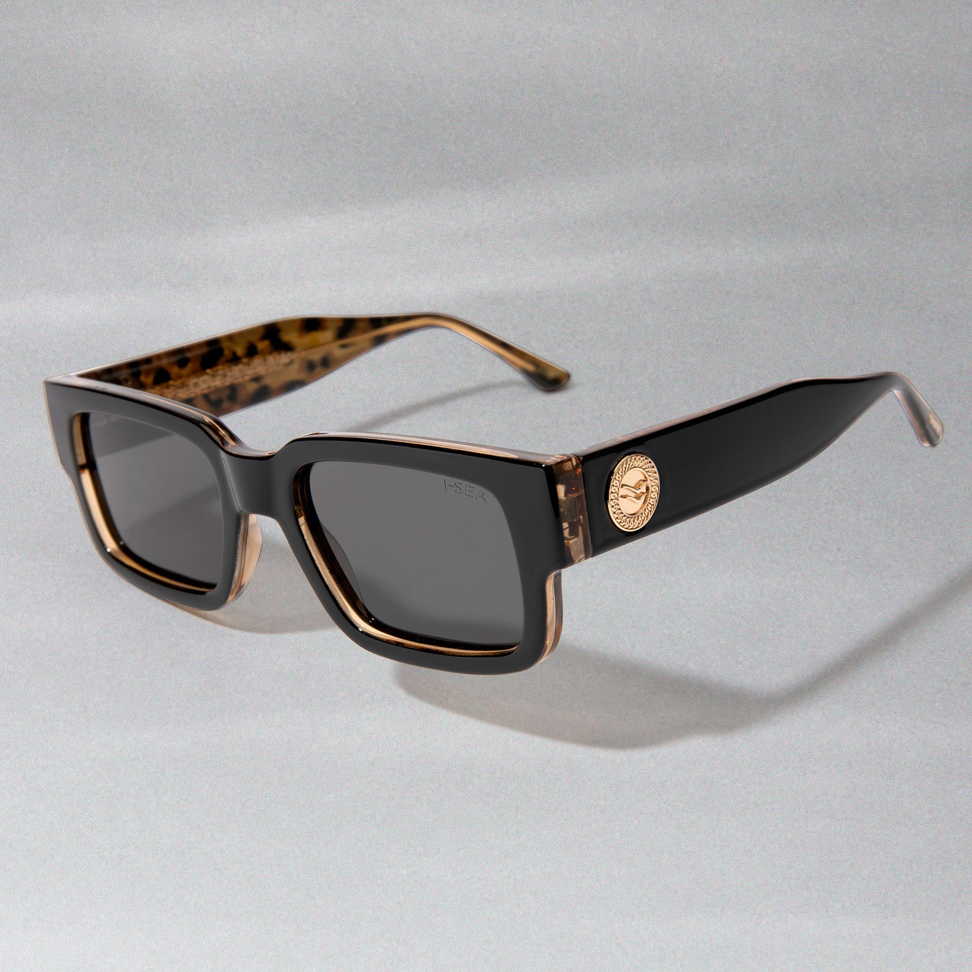 Sunglasses with tortoiseshell and gold accents on a light gray background.
BLACK LEOPARD / SMOKE POLARIZED LENS
