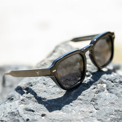 Sunglasses on a rock with a blurred natural background.
BLACK / SMOKE POLARIZED LENS