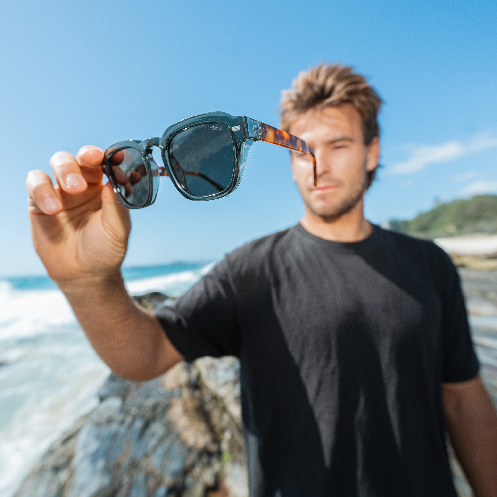 Man holding sunglasses with a beach and ocean background.
LEAF & TORT / TAUPE POLARIZED LENS