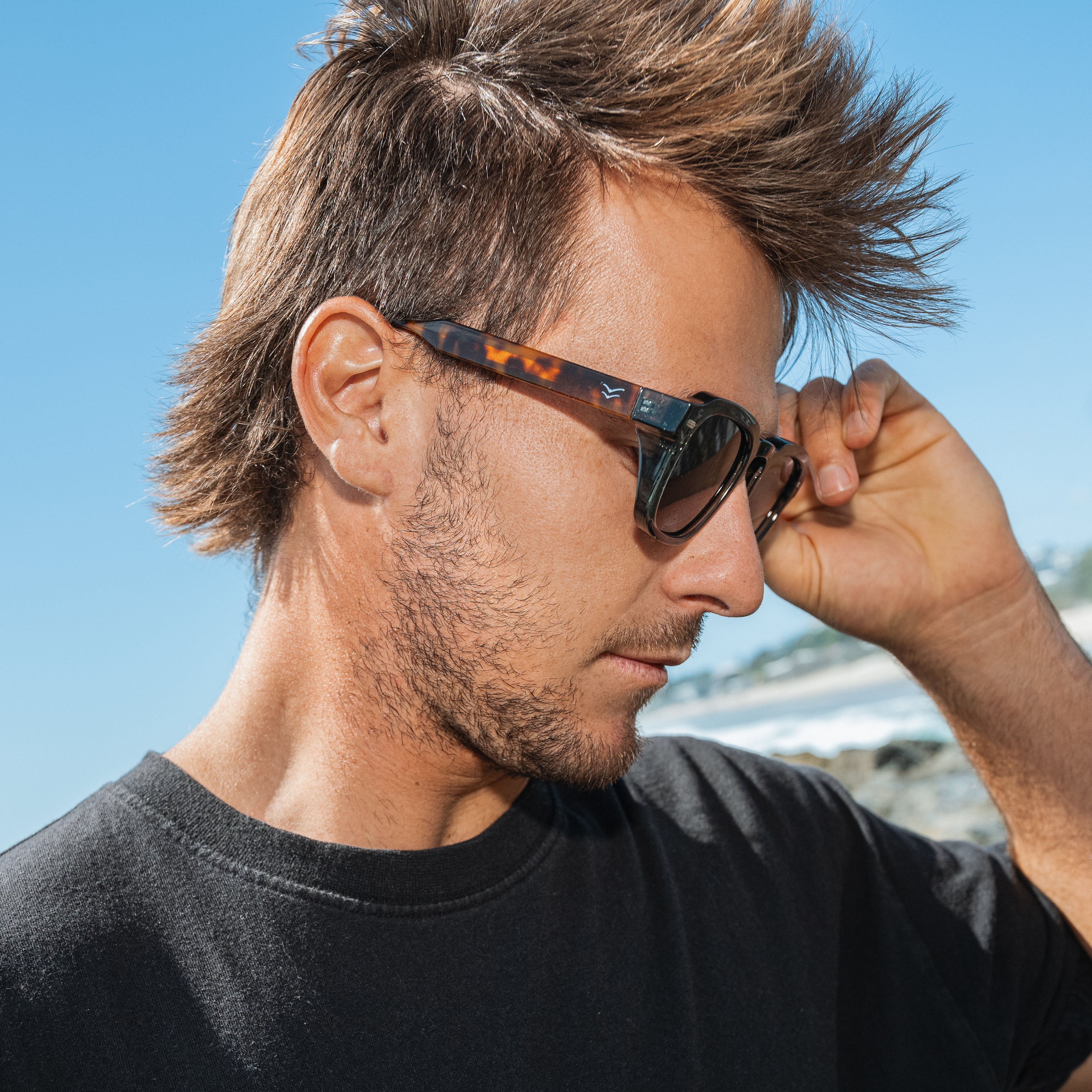 Man wearing sunglasses with a blurred background.
LEAF & TORT / TAUPE POLARIZED LENS