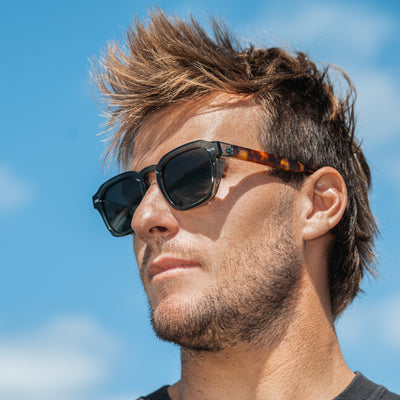 Man wearing sunglasses with a blue sky background.
LEAF & TORT / TAUPE POLARIZED LENS