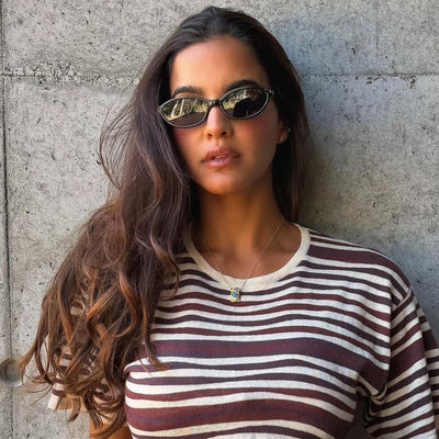 Woman wearing sunglasses and a striped shirt against a concrete wall.
BLACK / SMOKE POLARIZED LENS