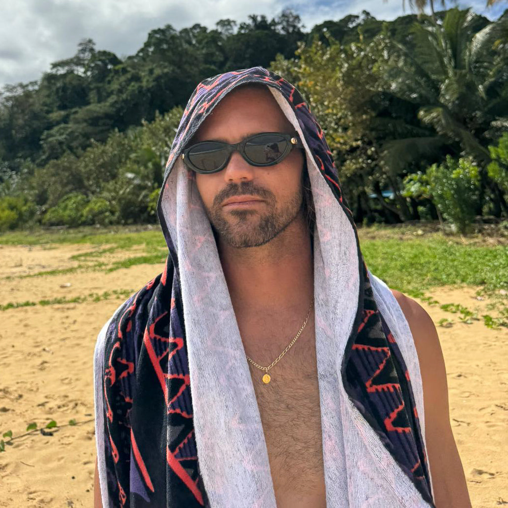 Man wearing sunglasses and a patterned towel on his head outdoors with greenery in the background.
BLACK / SMOKE POLARIZED LENS