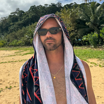 Man wearing sunglasses and a patterned towel on his head outdoors with greenery in the background.
BLACK / SMOKE POLARIZED LENS