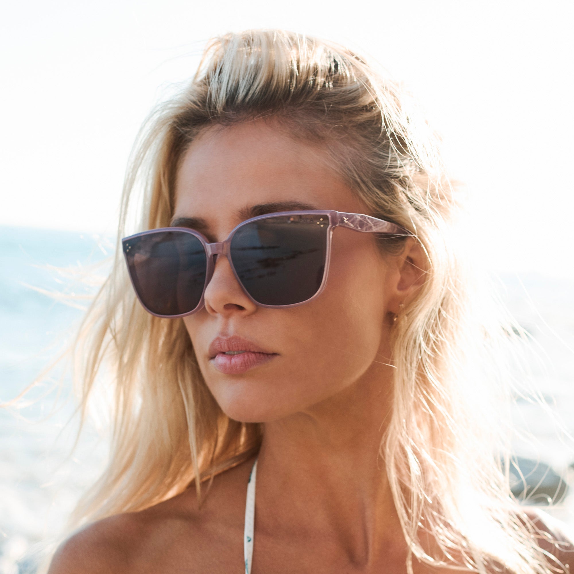 Woman wearing sunglasses with a blurred background.
DUSTY ROSE / PLUM POLARIZED LENS
