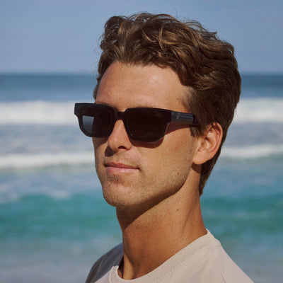 Man wearing sunglasses with a beach background.
BLACK / SMOKE POLARIZED LENS