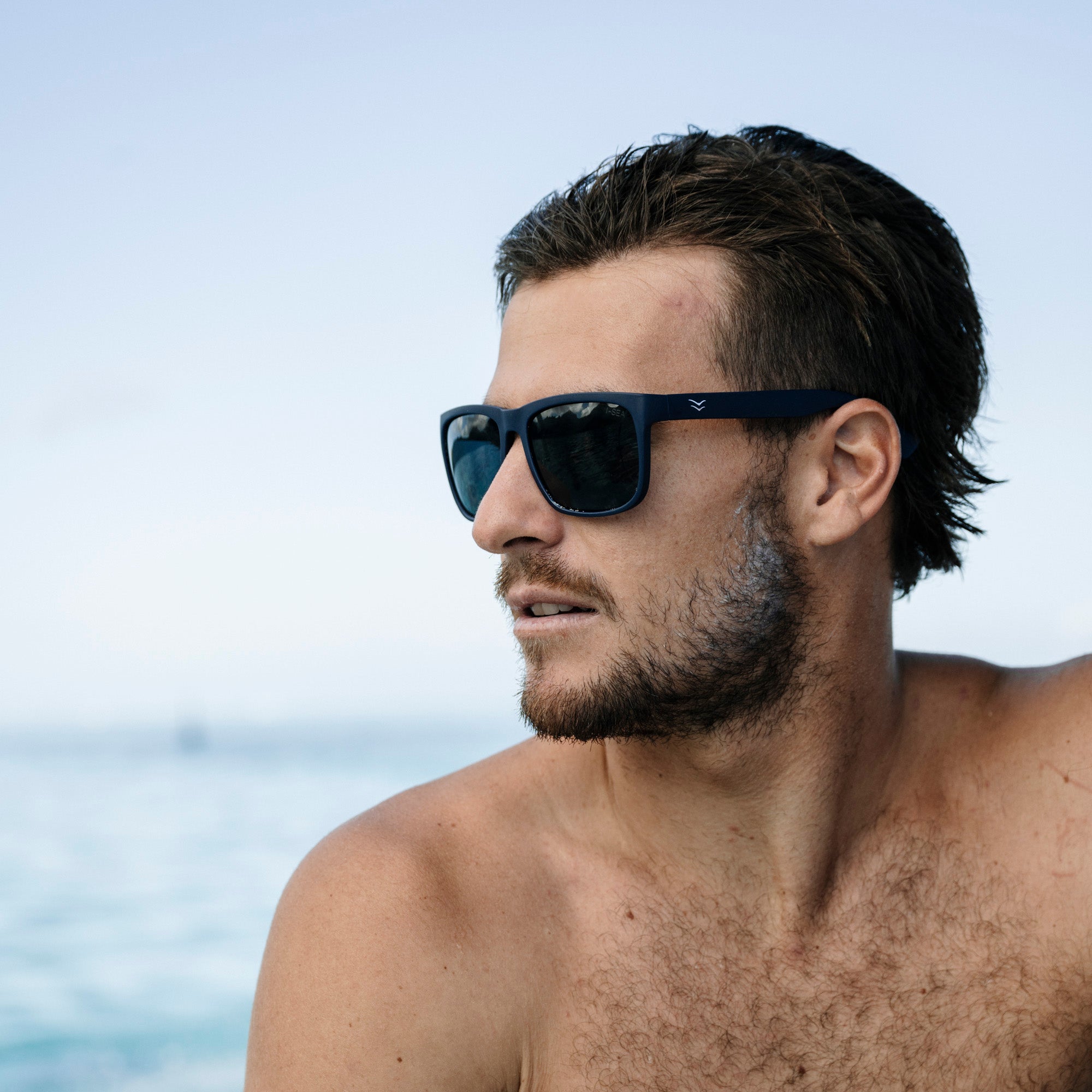 Man wearing sunglasses with a blurred ocean background.
SEA / SMOKE POLARIZED LENS