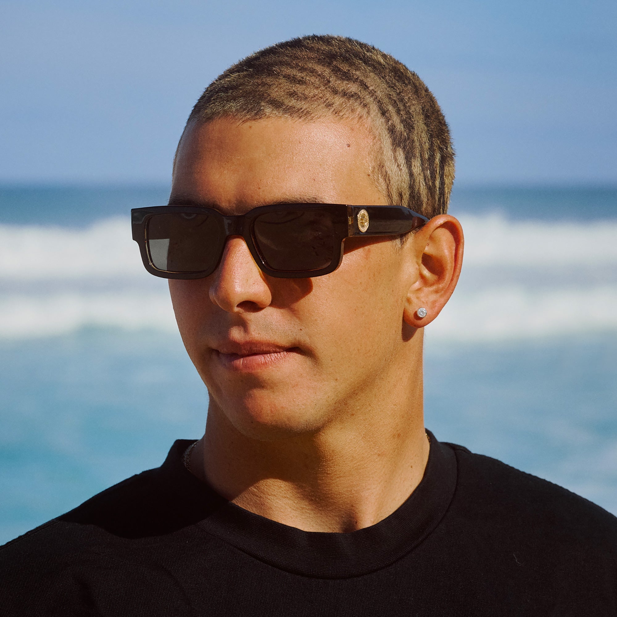 Person wearing sunglasses with a beach background.
BLACK LEOPARD / SMOKE POLARIZED LENS