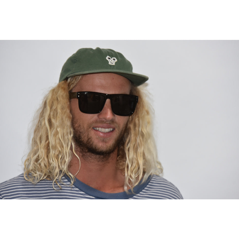 Man with long blonde hair wearing a green cap and dark sunglasses against a plain background.
BLACK SOFT TOUCH RUBBER / SMOKE POLARIZED LENS